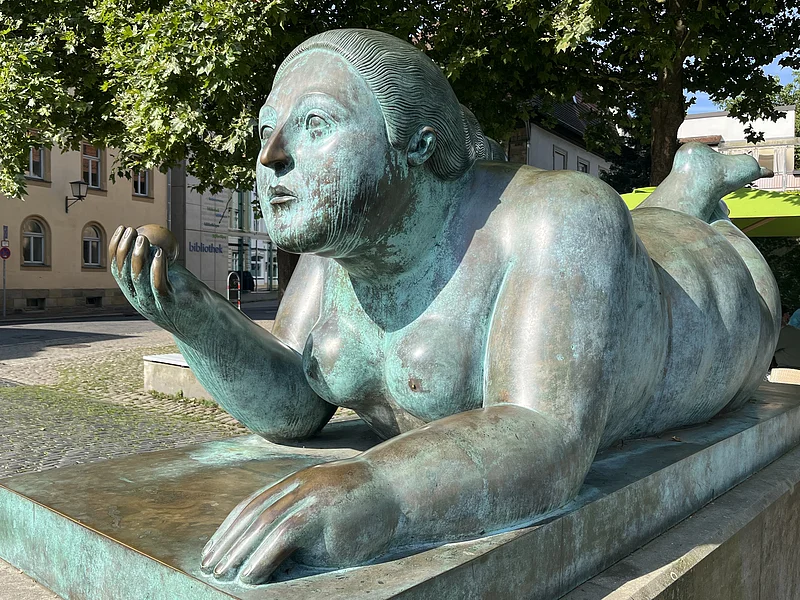"Liegende mit Frucht" von Fernando Botero Von den Bambergern liebevoll „Dicke Frau“ oder „Blunnzn“ genannt, ist die Skulptur „Liegende mit Frucht“ des kolumbianischen Künstlers Fernando Botero ein markantes Kunstwerk in Bamberg.